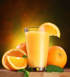 绿色叶子木板上的果汁与橙子图片